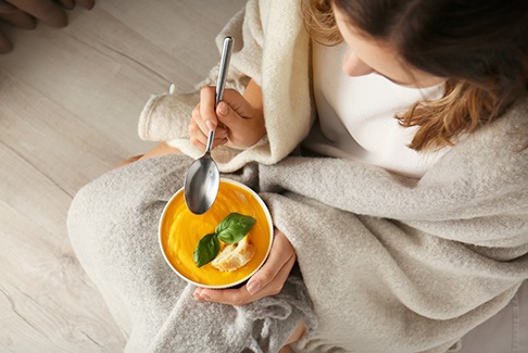 A woman eating soup at home