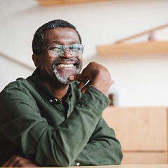 a man with glasses smiling