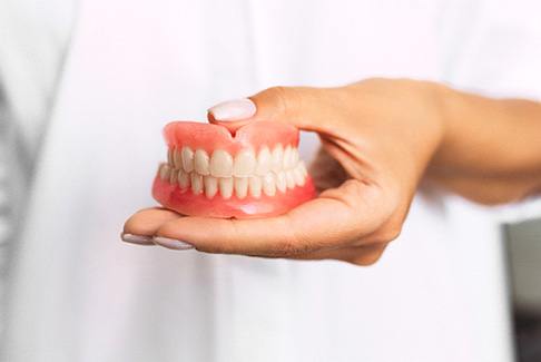 person holding dentures