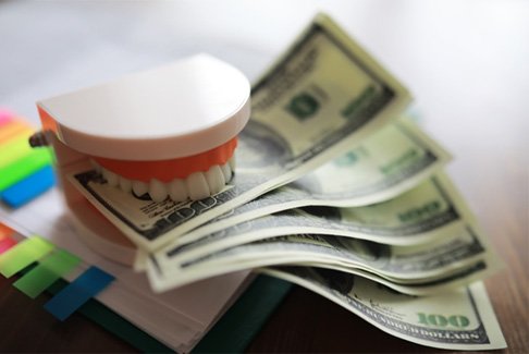 a folder with a model of a mouth and money sitting on top of it