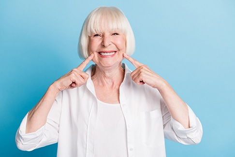 Woman pointing to her smile