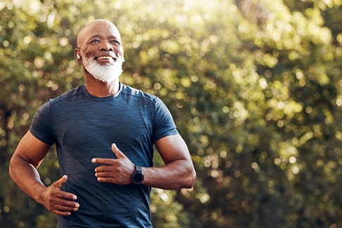 Senior man with beard jogging outside