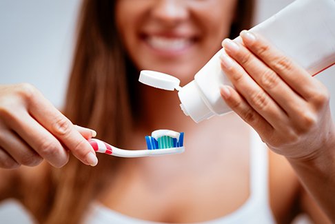Woman holding a toothbrush and toothpaste