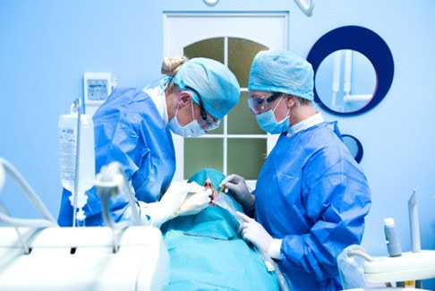 Dentists performing dental implant surgery