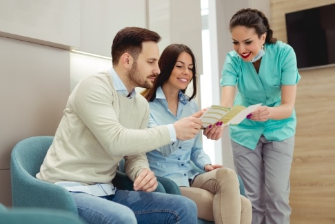 Dentist and dentistry patients discussing dental insurance coverage