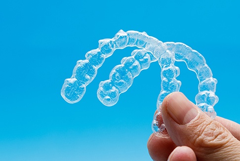 dentist holding two clear aligners