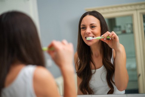 a patient brushing their teeth in Sterling Heights