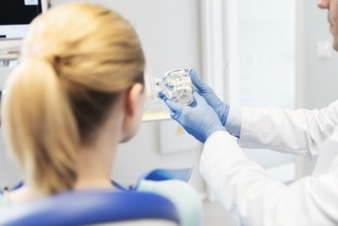 Dentist and dental patient talking during preventive dentistry checkup and teeth cleaning visit