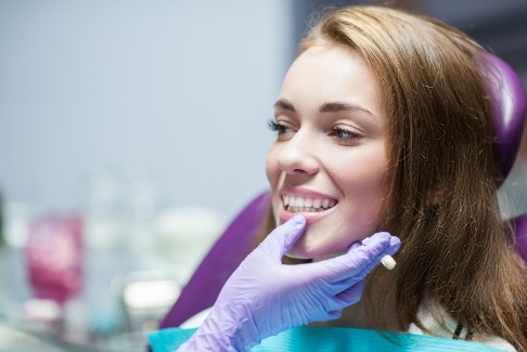 Dentist examining smile after dental crown restoration