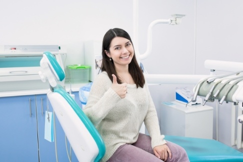 Smiling woman giving thumbs up after one visit dental restoration