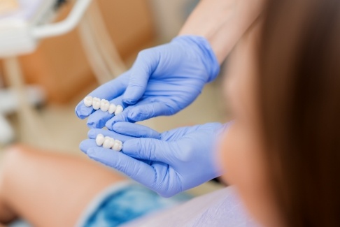 Dentist showing dentistry patient two dental bridges