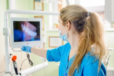 Dentist using intraoral camera to take a closer look at dental patient's smile