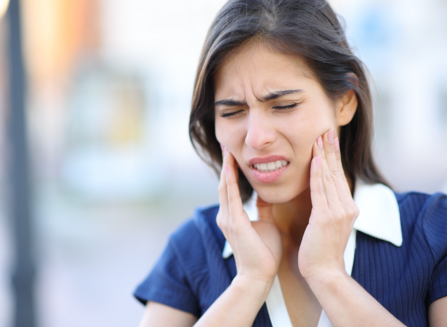 Woman holding jaw, in pain